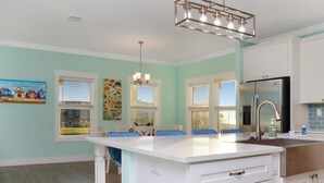 A kitchen with white cabinets, a stainless steel refrigerator, and a pendant light. - ☀️ Short Walk to Beach - Easy Beach Access - Blue Pelican ☀️ (Mexico Beach)