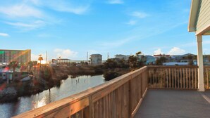 A wooden deck overlooking a calm body of water with buildings in the background. - ☀️ Short Walk to Beach - Easy Beach Access - Blue Pelican ☀️ (Mexico Beach)