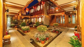 Un bâtiment traditionnel en bois, doté d’une cour intérieure, de poutres en bois et de lanternes.