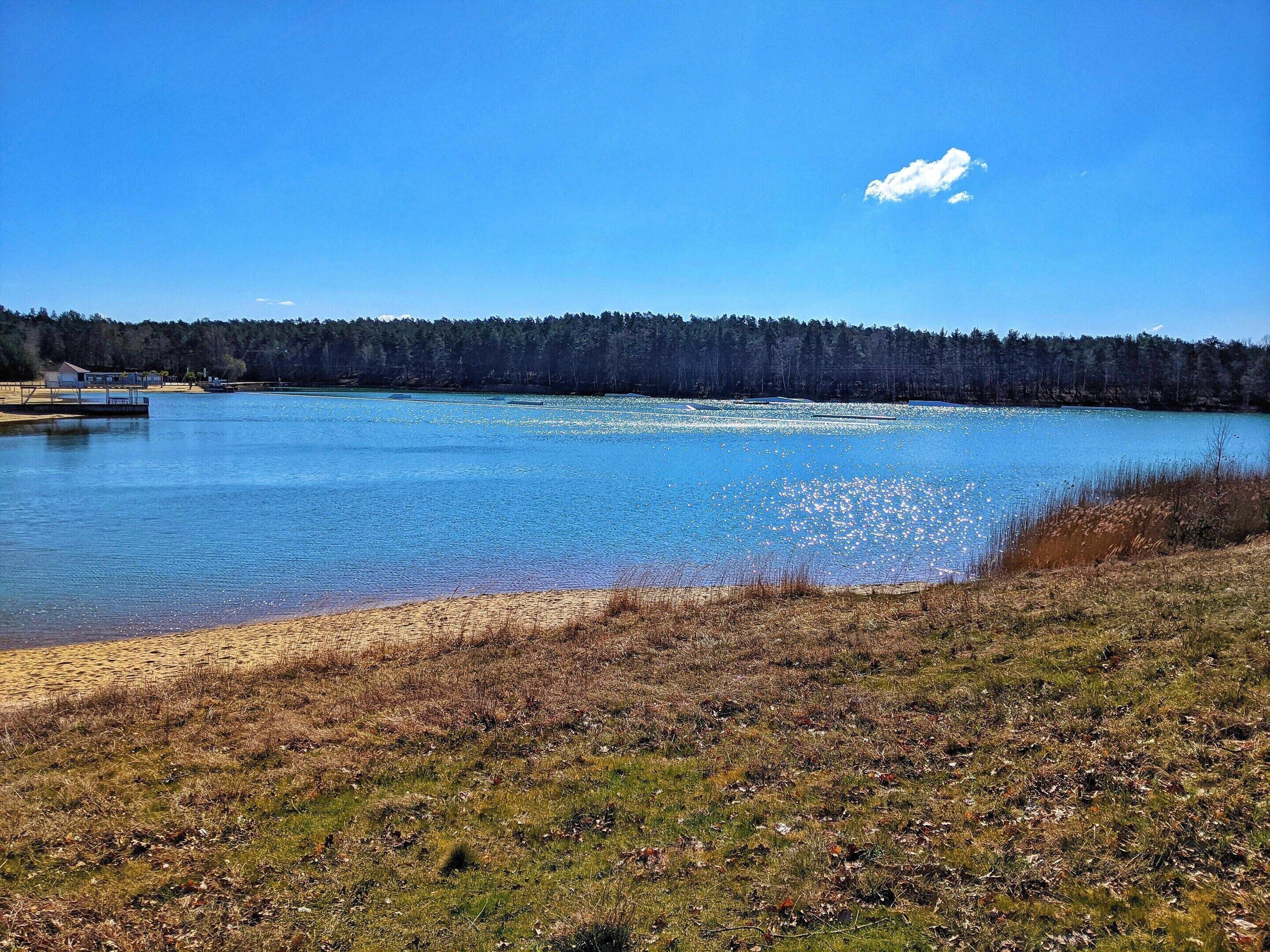 Ein See mit Steg, umgeben von Wald.
