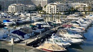 A marina with numerous boats docked, surrounded by residential buildings and a clear sky. - Le Masters Golf and Sea (Mandelieu-la-Napoule)