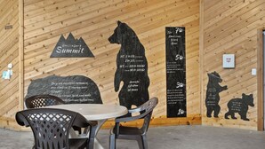 Ein Holzinnenraum mit einem Tisch und Stühlen, einer Bärensilhouette und einem Schild mit der Aufschrift "Gatlingburg Summit".