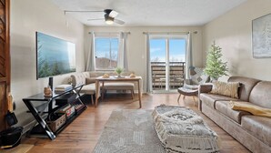 Ein Wohnzimmer mit Sofa, Couchtisch, Fernseher und Deckenventilator.