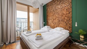 Una camera d'albergo moderna con un letto grande, vista sulla città e una parete decorata in legno.