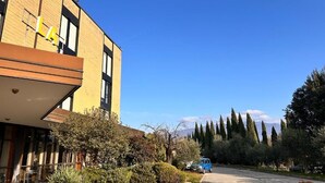 A building with a 'LA' sign, a parking area, and a clear sky.