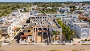 Un quartier résidentiel avec des maisons modernes, un bâtiment central doté d’un escalier et un ciel dégagé.