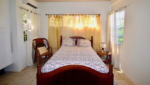Un dormitorio con una cama de madera, una silla, una mesita de noche y una ventana con cortinas.