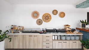 Una cuina moderna amb una illa central, diferents dosificadors d'aliments i elements decoratius a la paret.