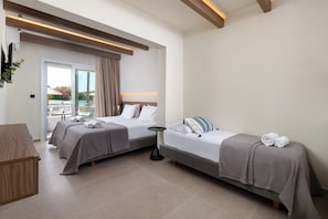 A hotel room with two beds, a small table, and a view of the outdoors. - Sam's Faliraki (Faliraki)