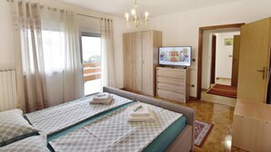 Un dormitorio con cama, televisión y armario.
