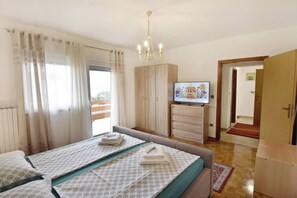Ein Schlafzimmer mit einem Bett, einem Fernseher und einem Kleiderschrank.