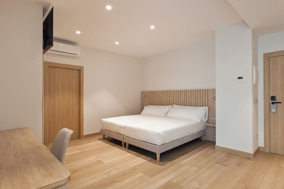 Un dormitorio con cama, escritorio y silla.