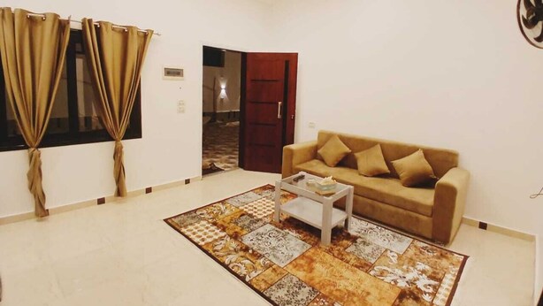 A living room with a beige sofa, a coffee table, and a patterned rug. - NOOR SEEN HOUSE  (Luxor)