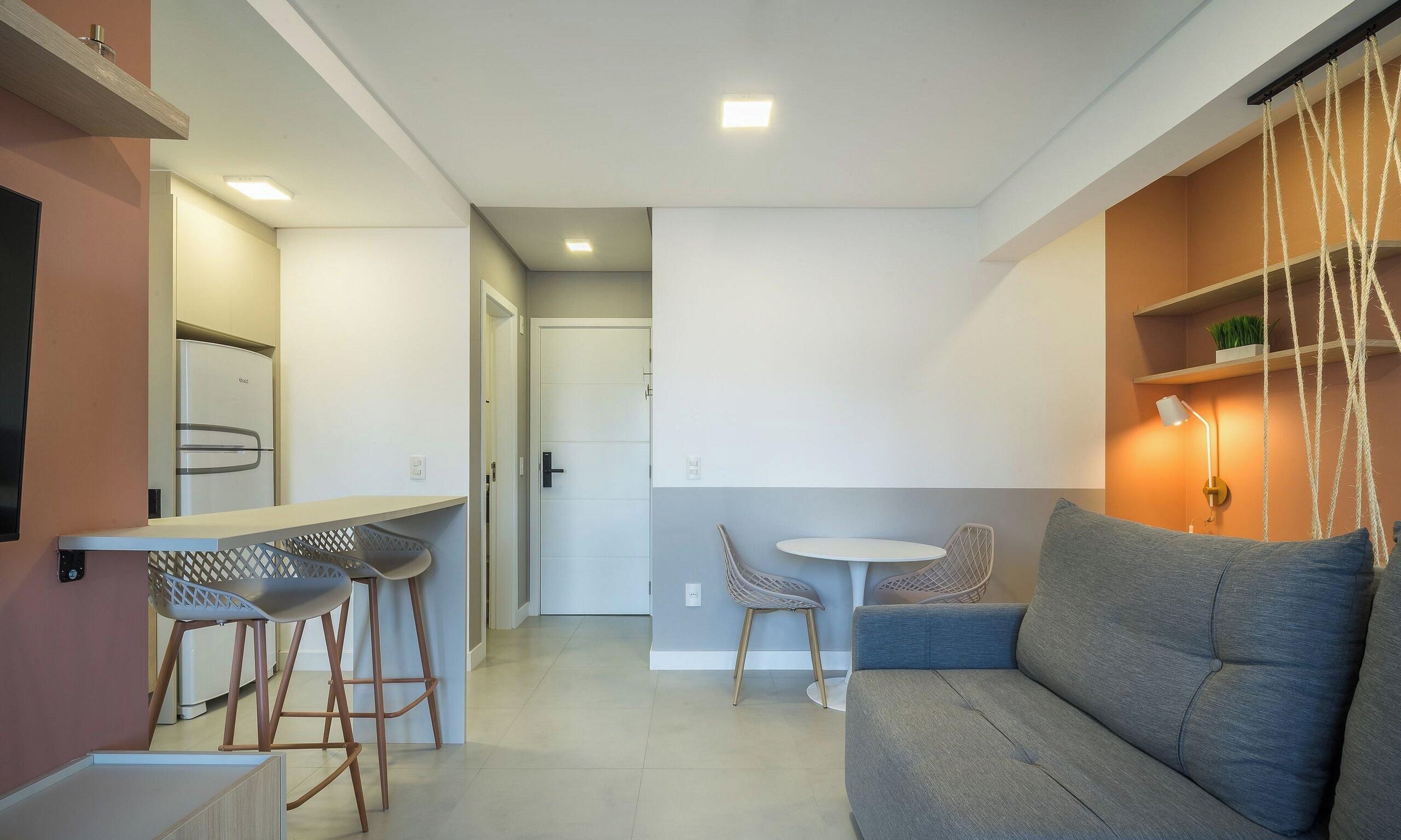 A modern living space with a kitchen, a dining area, and a seating area with a sofa and chairs.