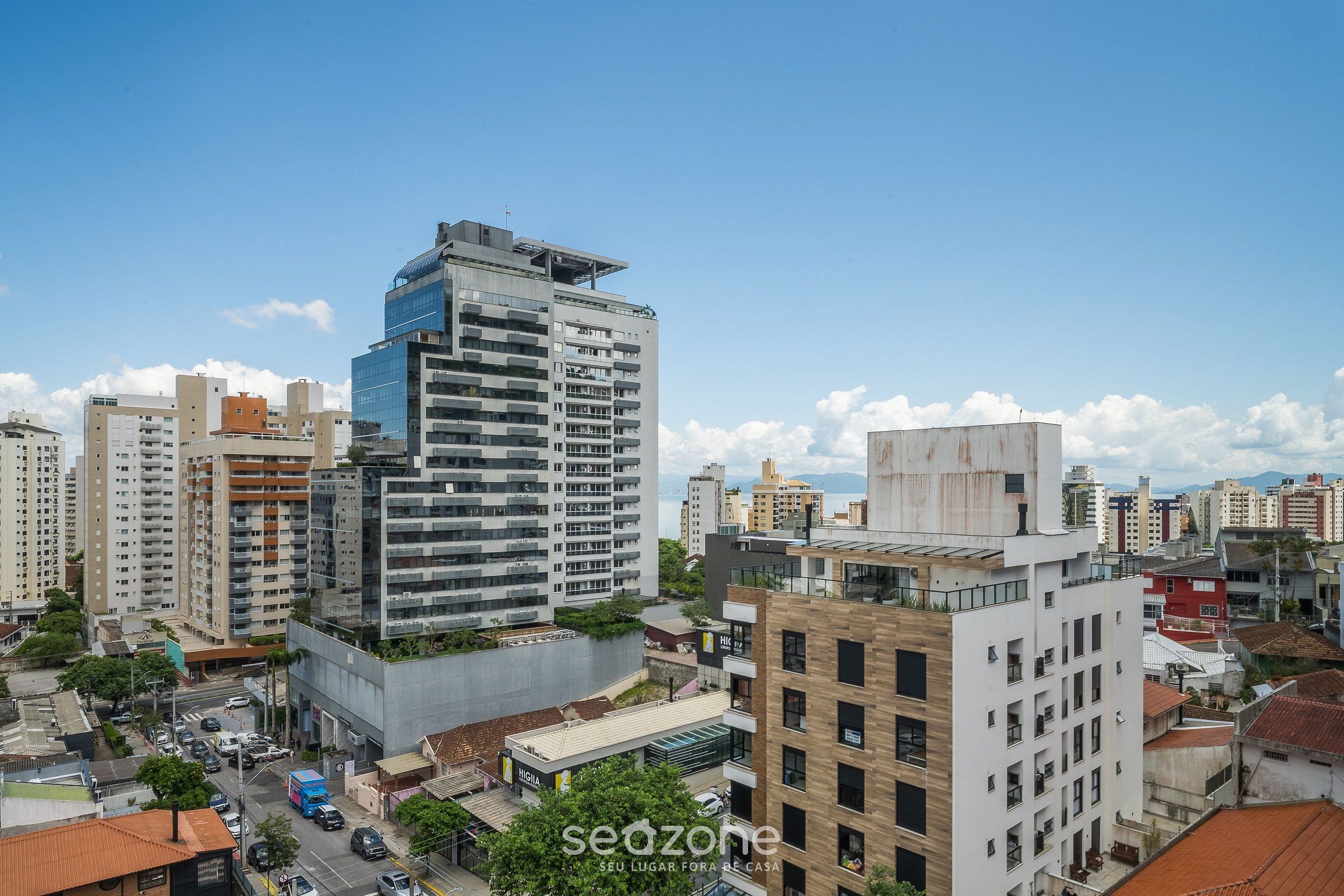 Un rascacielos de varios pisos, rodeado de otros edificios y un cielo despejado.