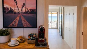 Ein Flur mit einer Kaffeemaschine, einer Obstschale und einer Zimmerpflanze.