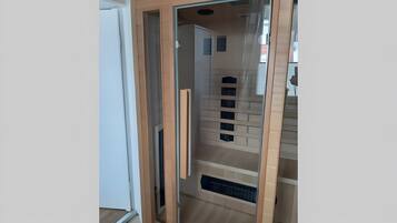 Ein Zimmer mit einer Schiebetür und anschließendem Kleiderschrank, der Regale und eine integrierte Sitzbank bietet.
