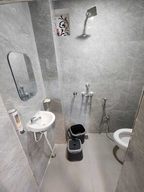 Ein modernes Badezimmer mit Waschbecken, Spiegel, Dusche und Toilette.