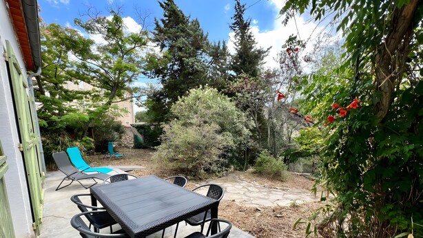 A patio with a table and chairs, surrounded by greenery and trees. - Holiday Home “L'angèle - Spacious With” with Private Terrace, Wi-Fi & Air Conditioning (Portel-des-Corbières)