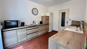A modern kitchen with a microwave, toaster, coffee maker, and refrigerator. - Holiday Home “L'angèle - Spacious With” with Private Terrace, Wi-Fi & Air Conditioning (Portel-des-Corbières)
