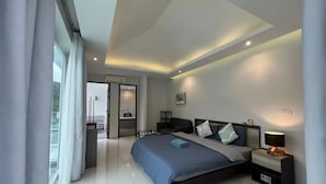 Ein modernes Schlafzimmer mit einem großen Bett, Nachttischen und Blick durch ein Fenster.