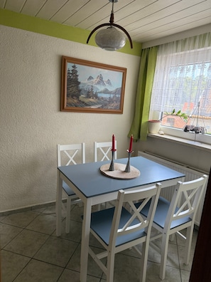 Ein Essbereich mit Tisch und Stühlen, einem Bild an der Wand und einem Fenster mit Blick.