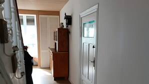 A hallway with wooden flooring, white walls, a wooden cabinet, and a door with a window. - Apartment 'Harz Idylle 2' with Wi-Fi (Güntersberge)