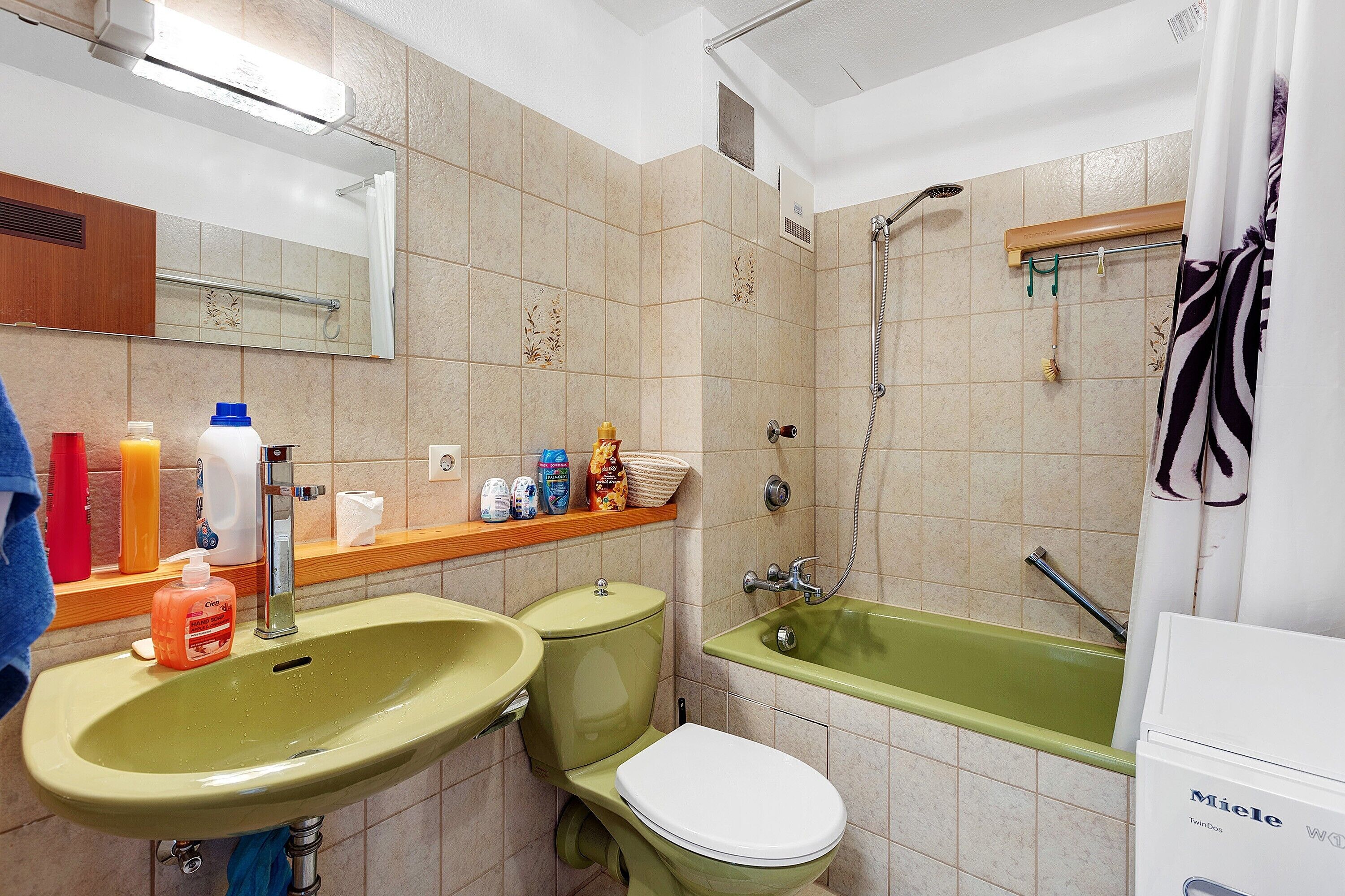 Une salle de bain avec un lavabo vert, des toilettes blanches et une baignoire.