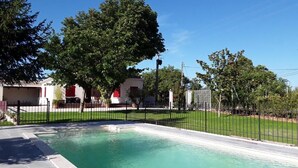 A swimming pool with a black fence, surrounded by a grassy area and trees. - Family Villa LA BONBONNE EN PROVENCE 8-10 pers 5 bedrooms, swimming pool, quiet, Vaucluse (Travaillan)