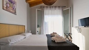 Une chambre à coucher avec un lit, une télévision, une armoire et une fenêtre avec des rideaux.