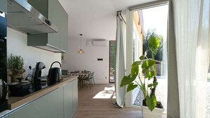 Una cocina moderna con encimera de madera, hervidor y planta en maceta.