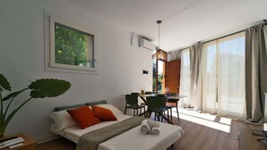 Una habitación de hotel moderna con una cama, un escritorio y un ventanal amplio.