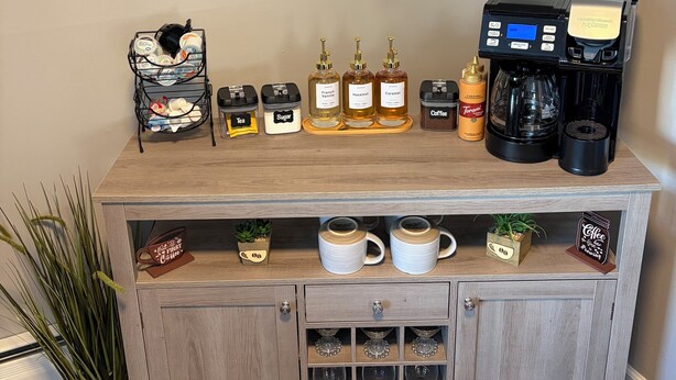 Eine Kaffeestation mit Kaffeemaschine, Zucker, Tee und Kaffeekannen.