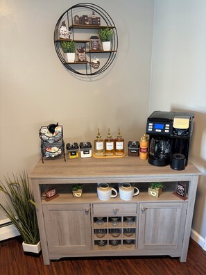 A coffee station with a coffee machine, sugar, tea, and coffee containers. - Enjoyable 2-bedroom 4-Guest Apartment with AC in charming Amherst,NY (Amherst)