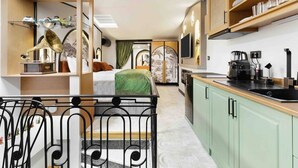 Ein kompaktes Hotelzimmer mit Küchenzeile, einem Essbereich und einem separaten Schlafbereich.