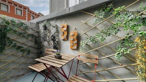 A rooftop garden with a wooden table, bamboo trellis, and hanging planters. - Daphne Pera ; Sakura Apart, City Center (Beyoglu)