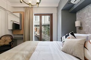A hotel room with a bed, a TV, a chair, a window with curtains, and a balcony with plants. - Daphne Pera ; Sakura Apart, City Center (Beyoglu)
