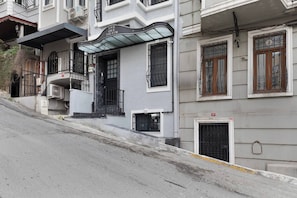 Ein Gebäude mit überdachter Eingangspartei, einem Balkon und einer kleinen Tür.