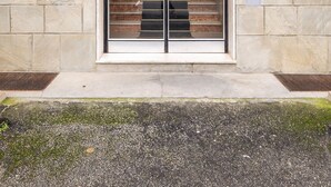 A modern building entrance with a large glass door, stone walls, and a small mailbox on the left. - Casa Amarenzi by Wonderful Italy (Bologna)
