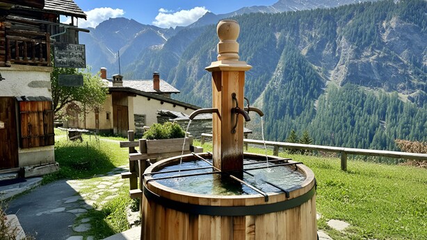 A wooden water pump in a rural setting with a mountain backdrop. - CASA-Niu Luxe discret, vue et pied des pistes (Molines-en-Queyras)