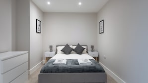 A modern bedroom with a bed, bedside tables, and a dresser. - Chic 1Bed in Hull City Centre near Hull College (Hull)