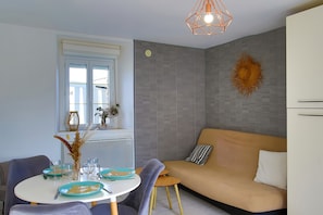 Un soggiorno moderno con divano, tavolo da pranzo e un elemento decorativo a parete.