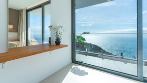 Ein modernes Zimmer mit großem Fenster und Blick auf die Küste.
