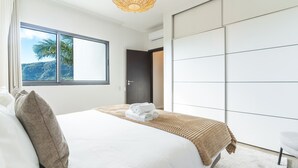 Una camera da letto moderna con un letto grande, vista sull'esterno e un armadio.