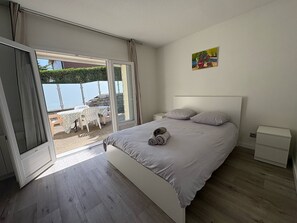 A bedroom with a bed, a nightstand, and a painting on the wall. - House near Zenith in southern Clermont-Ferrand   (La Roche-Blanche)