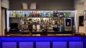 Una zona de bar con una variedad de botellas de licores, una caja registradora y una máquina de café.