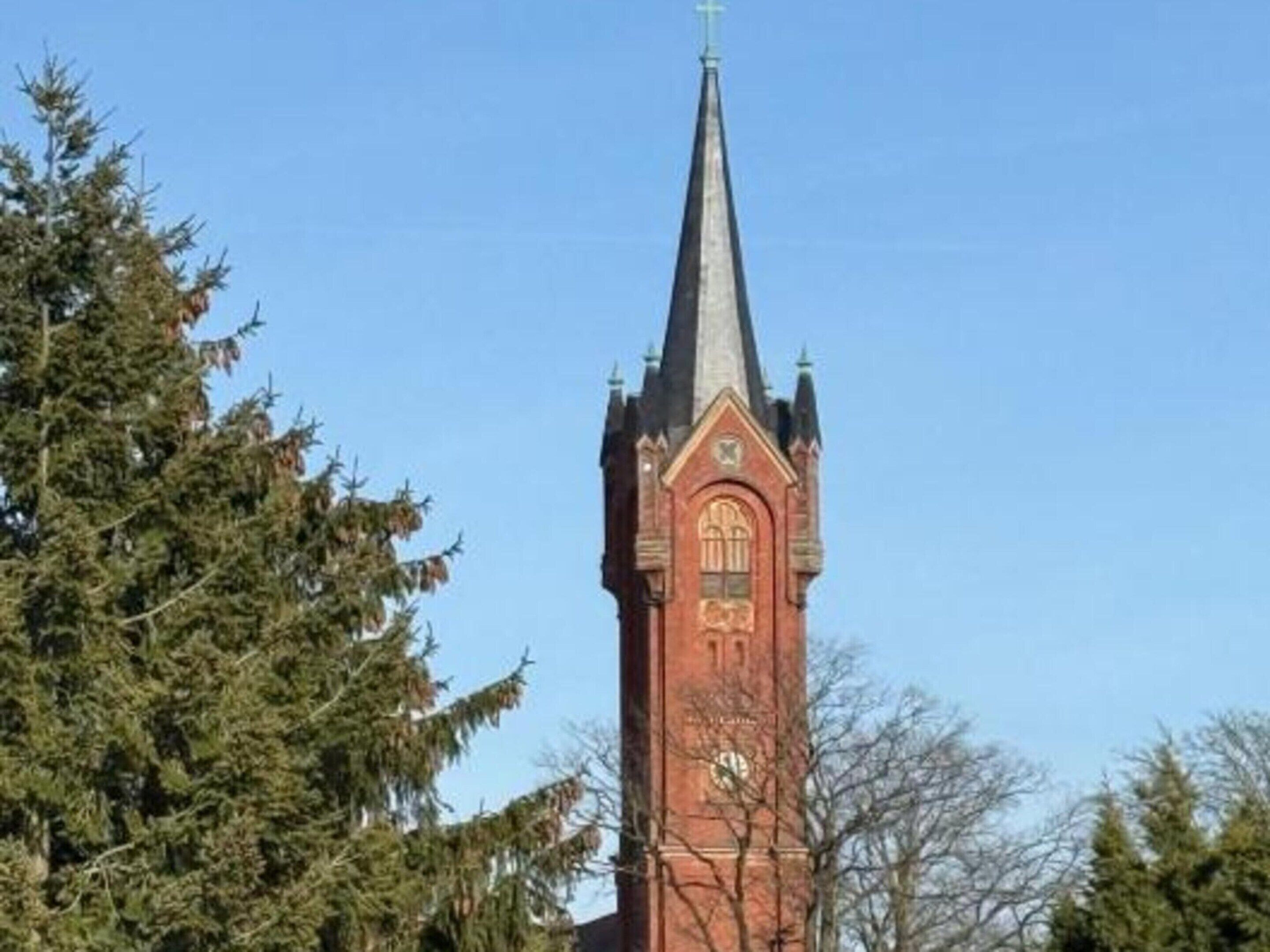 A church with a tall spire and a clock tower.