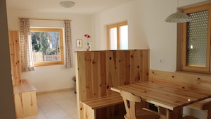 Een houten eethoek met een bank, tafel en stoelen.