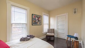 A bedroom with a bed, a chair, a desk, and a door. - 3-Bedroom in Downtown Columbus (Columbus)