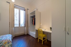 A bedroom with a bed, a desk, a chair, a wardrobe, and a window. - GuestHost - Cozy and bright 87 square meters apartment, perfect for five people, located on the second floor of a building (no elevator).The property is located on the island of Ortigia (Restricted-Traffic Area), the historic and cultural heart of Syracu (Syracuse)